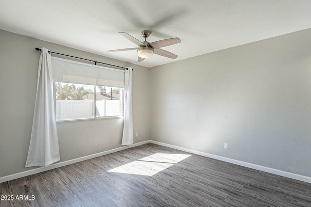 spare room with ceiling fan, baseboards, and wood finished floors