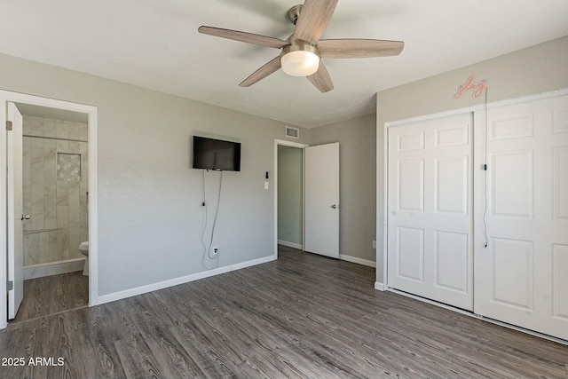 unfurnished bedroom with baseboards, visible vents, ensuite bath, wood finished floors, and a closet