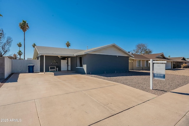 single story home featuring fence and concrete driveway