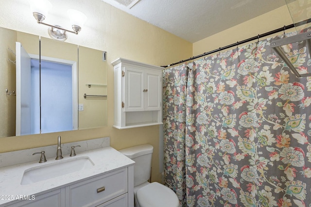 full bathroom featuring a textured ceiling, a shower with shower curtain, vanity, and toilet