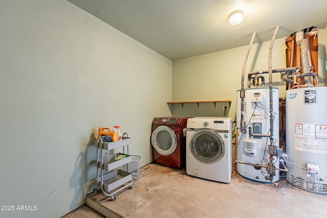 washroom with gas water heater, water heater, washing machine and clothes dryer, and laundry area