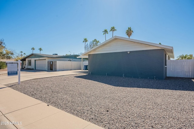 view of home's exterior featuring a garage, fence, and an outbuilding