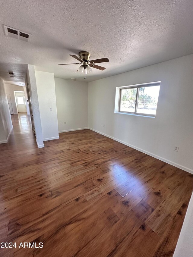 empty room with hardwood / wood-style floors, french doors, a textured ceiling, and ceiling fan