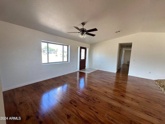 spare room with a textured ceiling, dark hardwood / wood-style floors, vaulted ceiling, and ceiling fan