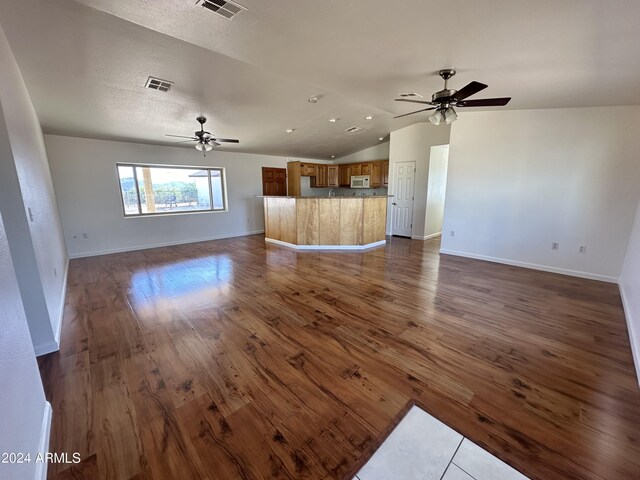 unfurnished living room with ceiling fan, lofted ceiling, and hardwood / wood-style flooring