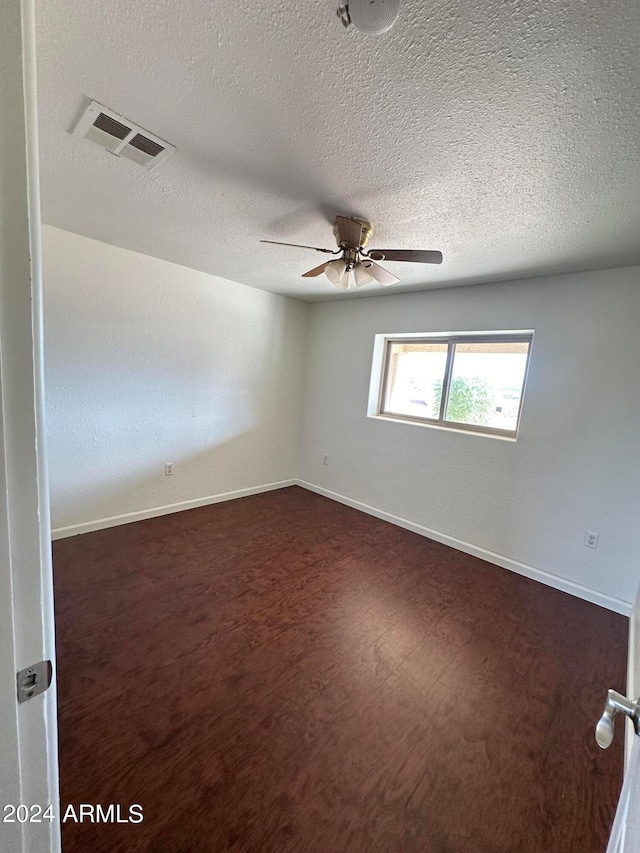 spare room featuring a textured ceiling, wood-type flooring, and ceiling fan