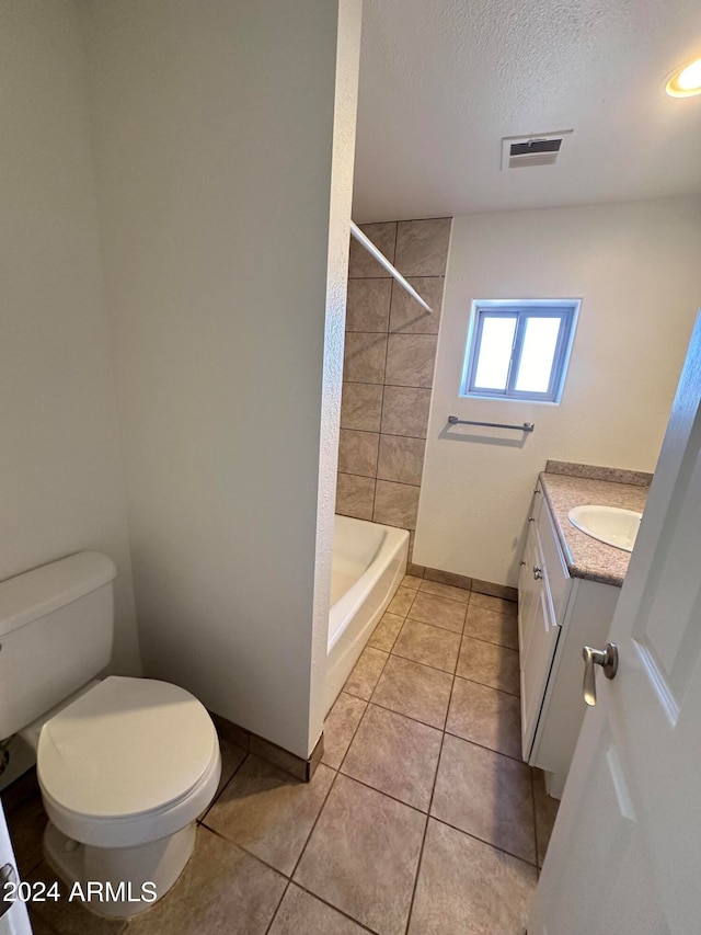 bathroom with a textured ceiling, toilet, vanity, and tile patterned flooring