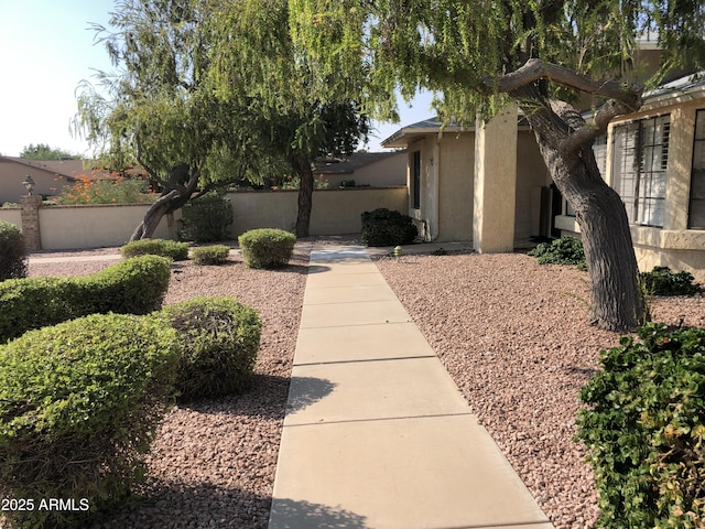 view of side of home with fence and stucco siding