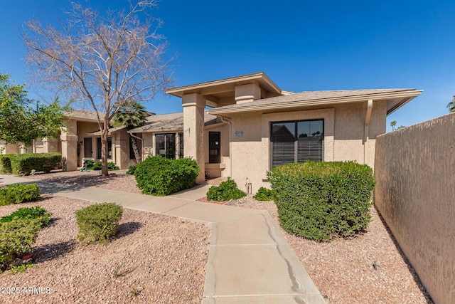 view of front of home with fence and stucco siding