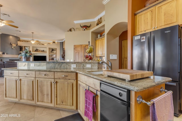 kitchen featuring a sink, light brown cabinets, and freestanding refrigerator