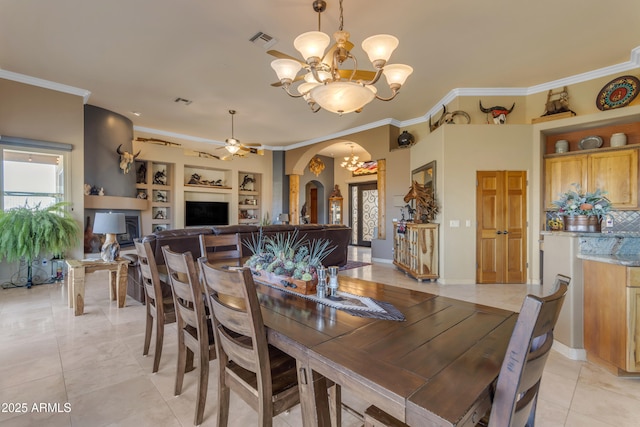 dining space featuring visible vents, crown molding, built in features, light tile patterned flooring, and arched walkways