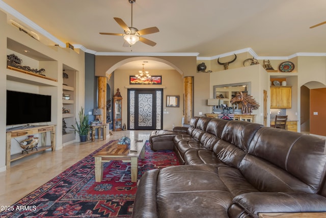 living area with built in features, ceiling fan with notable chandelier, arched walkways, and ornamental molding