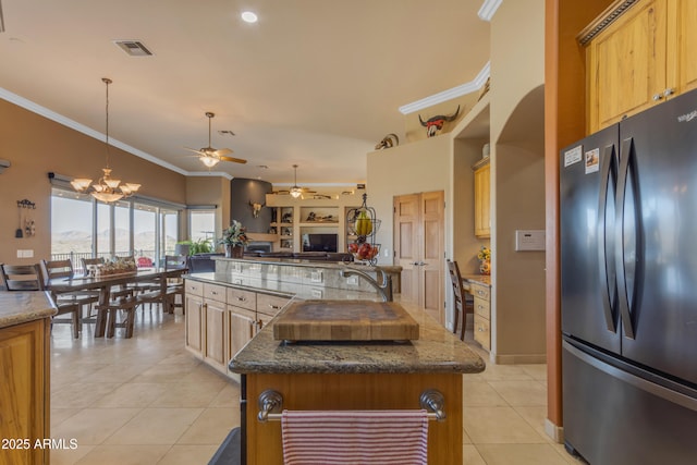 kitchen featuring ornamental molding, a spacious island, open floor plan, freestanding refrigerator, and light tile patterned floors