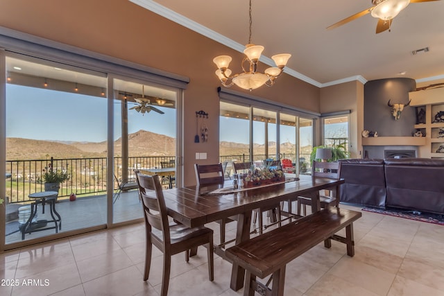 dining area featuring visible vents, ceiling fan with notable chandelier, a mountain view, and ornamental molding