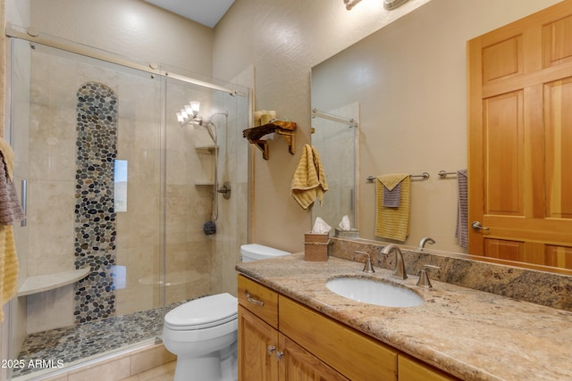 full bath with vanity, toilet, and a stall shower