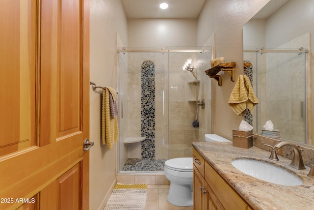 bathroom with vanity, tile patterned floors, toilet, and a stall shower