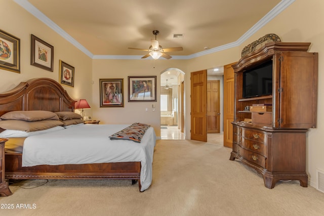 bedroom with visible vents, light carpet, ornamental molding, connected bathroom, and arched walkways