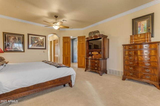 bedroom with arched walkways, visible vents, light carpet, and crown molding