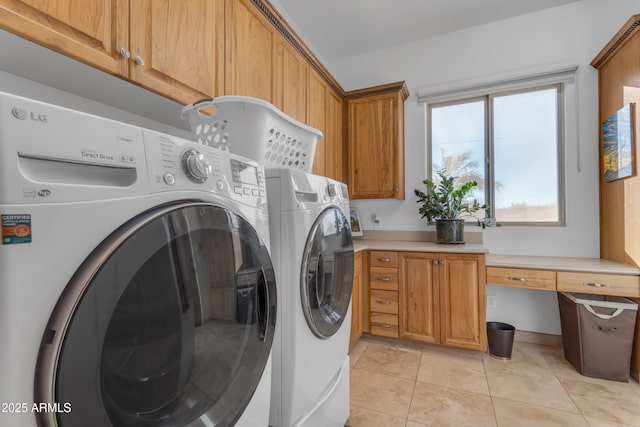 washroom with cabinet space, light tile patterned floors, and independent washer and dryer