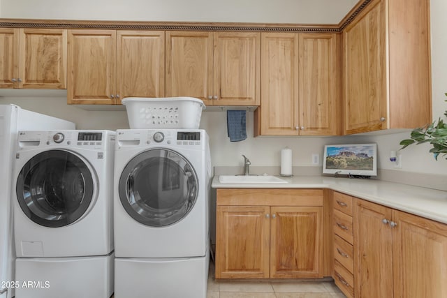 laundry room featuring separate washer and dryer, light tile patterned flooring, cabinet space, and a sink