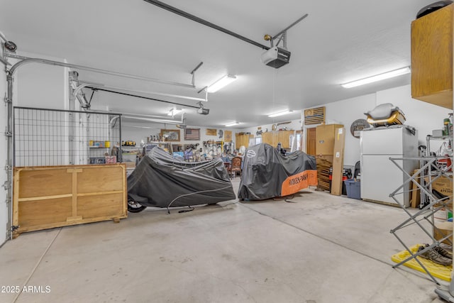 garage featuring a garage door opener and freestanding refrigerator