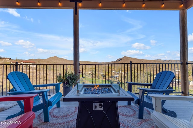 view of patio with a mountain view and an outdoor fire pit