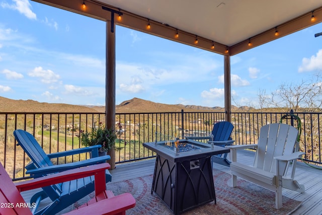 wooden terrace featuring a mountain view and an outdoor fire pit