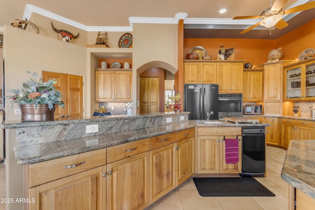 kitchen with tasteful backsplash, stainless steel microwave, light tile patterned floors, freestanding refrigerator, and arched walkways