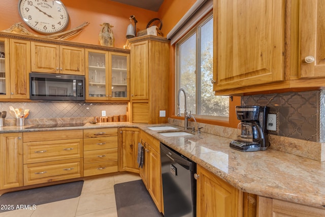 kitchen with a sink, light stone counters, light tile patterned floors, black electric cooktop, and dishwasher