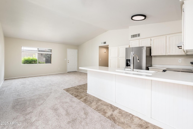3324 S Parkside Dr, Tempe, AZ 85282 - kitchen with stainless steel fridge with ice dispenser, stove, vaulted ceiling, white cabinetry, and light countertops