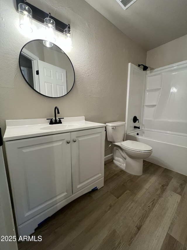 full bathroom featuring toilet, vanity, shower / washtub combination, and hardwood / wood-style floors