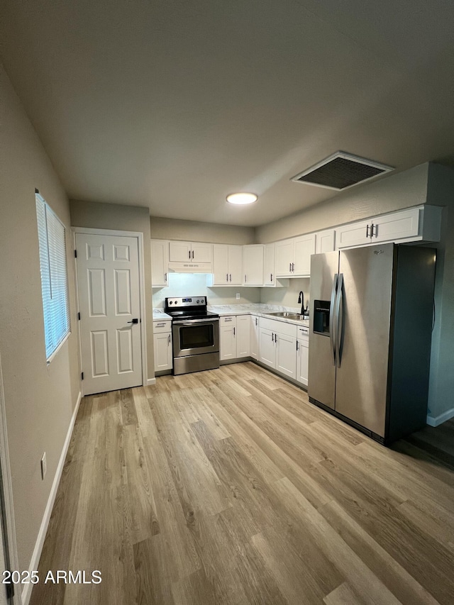 kitchen with white cabinetry, stainless steel appliances, light hardwood / wood-style flooring, and sink