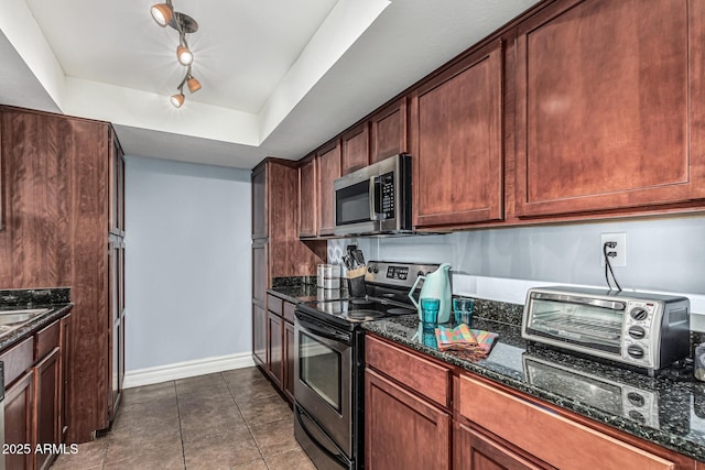 3825 E Camelback Rd Unit 152, Phoenix, AZ 85018 - kitchen with appliances with stainless steel finishes, dark stone countertops, baseboards, and dark tile patterned floors