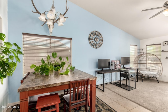 dining space with baseboards, ceiling fan with notable chandelier, high vaulted ceiling, and light tile patterned floors