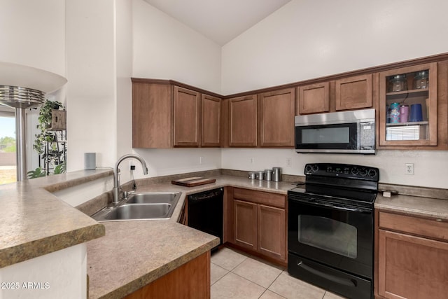 kitchen featuring a sink, a peninsula, light tile patterned flooring, black appliances, and high vaulted ceiling