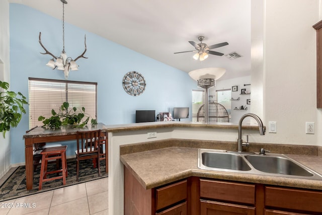 kitchen featuring light tile patterned flooring, visible vents, a sink, ceiling fan with notable chandelier, and open floor plan