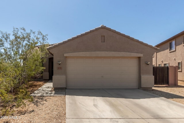 view of front of property with a tile roof, an attached garage, stucco siding, and driveway