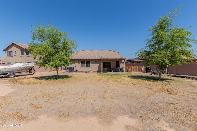 back of property featuring stucco siding and fence