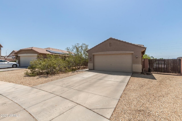 ranch-style home featuring a tile roof, fence, a garage, and stucco siding