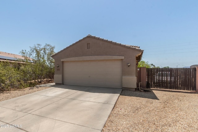 view of front facade featuring stucco siding, a garage, fence, and a tile roof