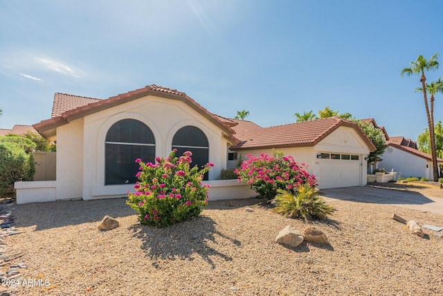 mediterranean / spanish home featuring a garage