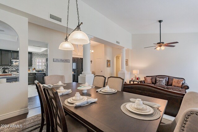 living room featuring ceiling fan, a fireplace, high vaulted ceiling, and dark wood-type flooring