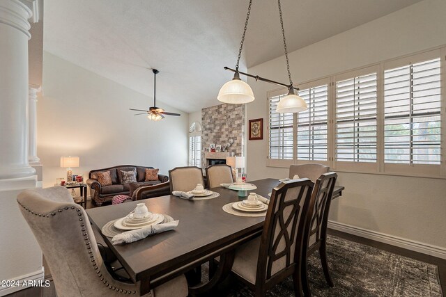 kitchen featuring ceiling fan with notable chandelier, a center island, light stone countertops, and lofted ceiling