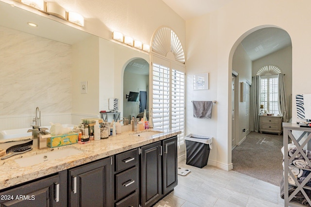 bathroom featuring tile patterned floors, a bathing tub, and double vanity