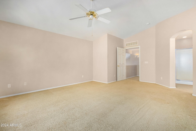 unfurnished room featuring ceiling fan, light colored carpet, and vaulted ceiling