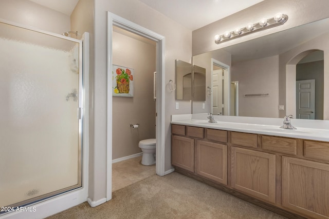 bathroom featuring toilet, an enclosed shower, and vanity