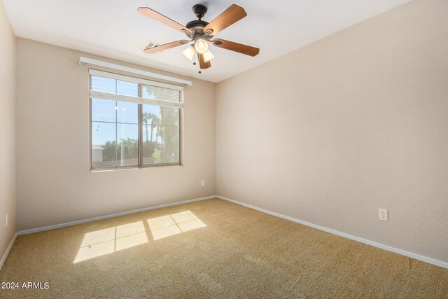 carpeted spare room with ceiling fan