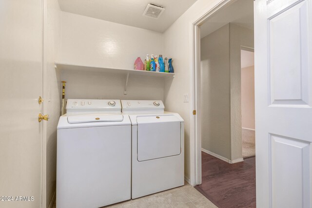 laundry area with separate washer and dryer and light tile patterned floors