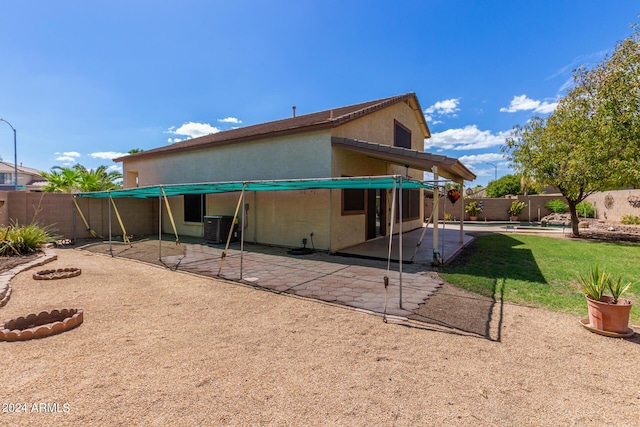 rear view of property with cooling unit and a patio area