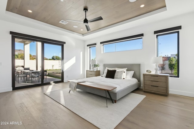 bedroom with access to exterior, a tray ceiling, ceiling fan, and wooden ceiling